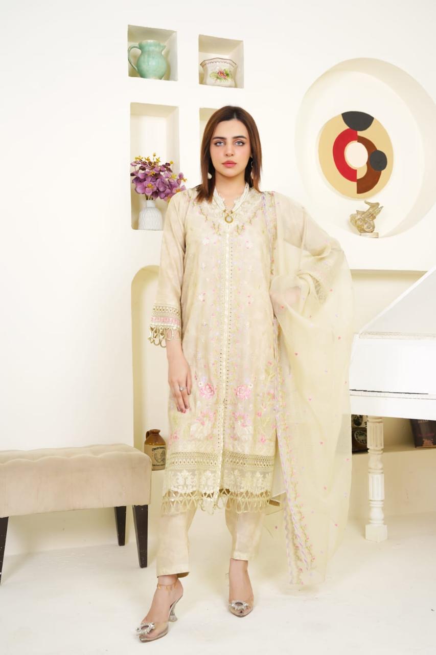 Woman wearing a cream embroidered outfit in a decorated room.