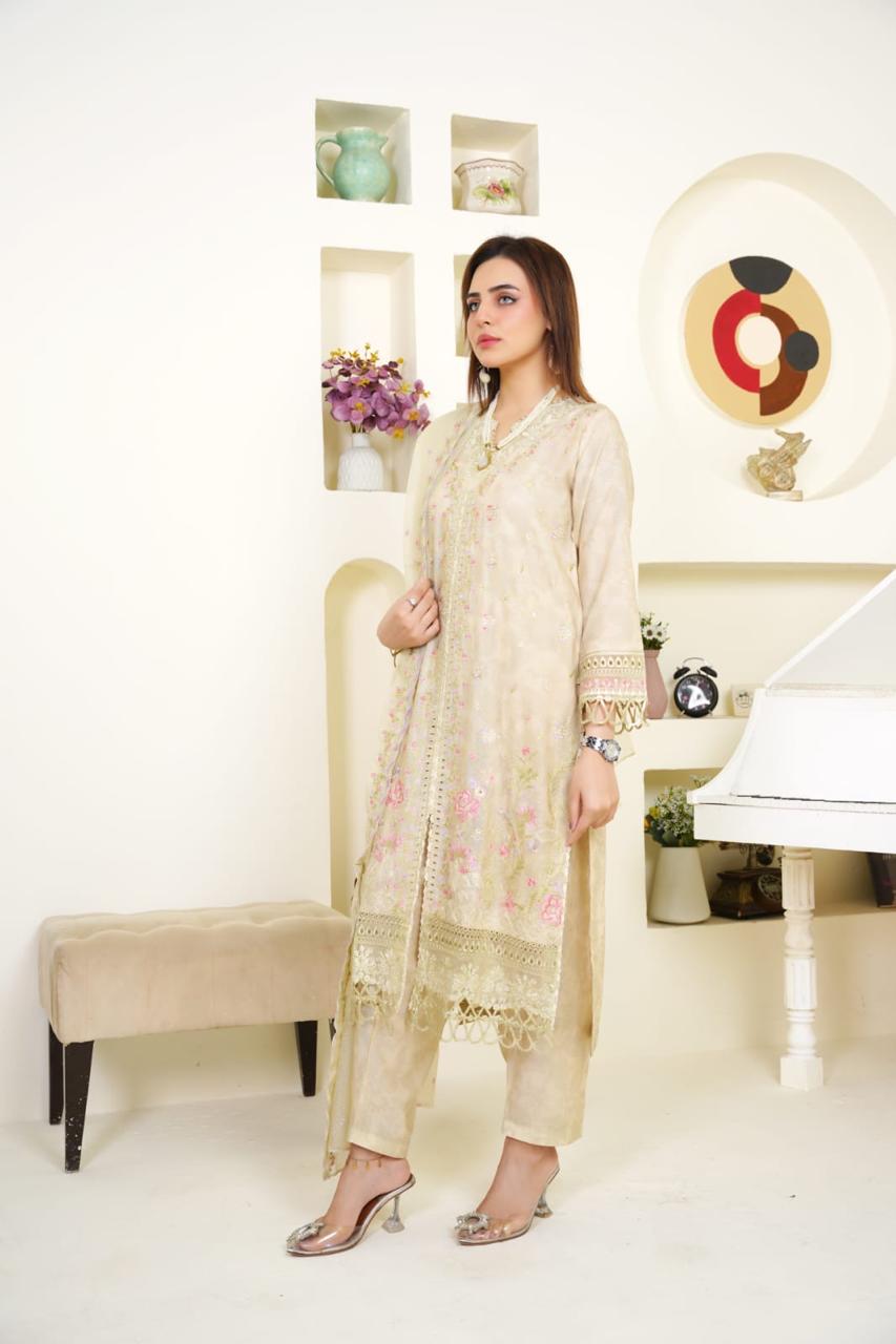 Woman in a light-colored traditional outfit standing in a stylish room with decor elements.