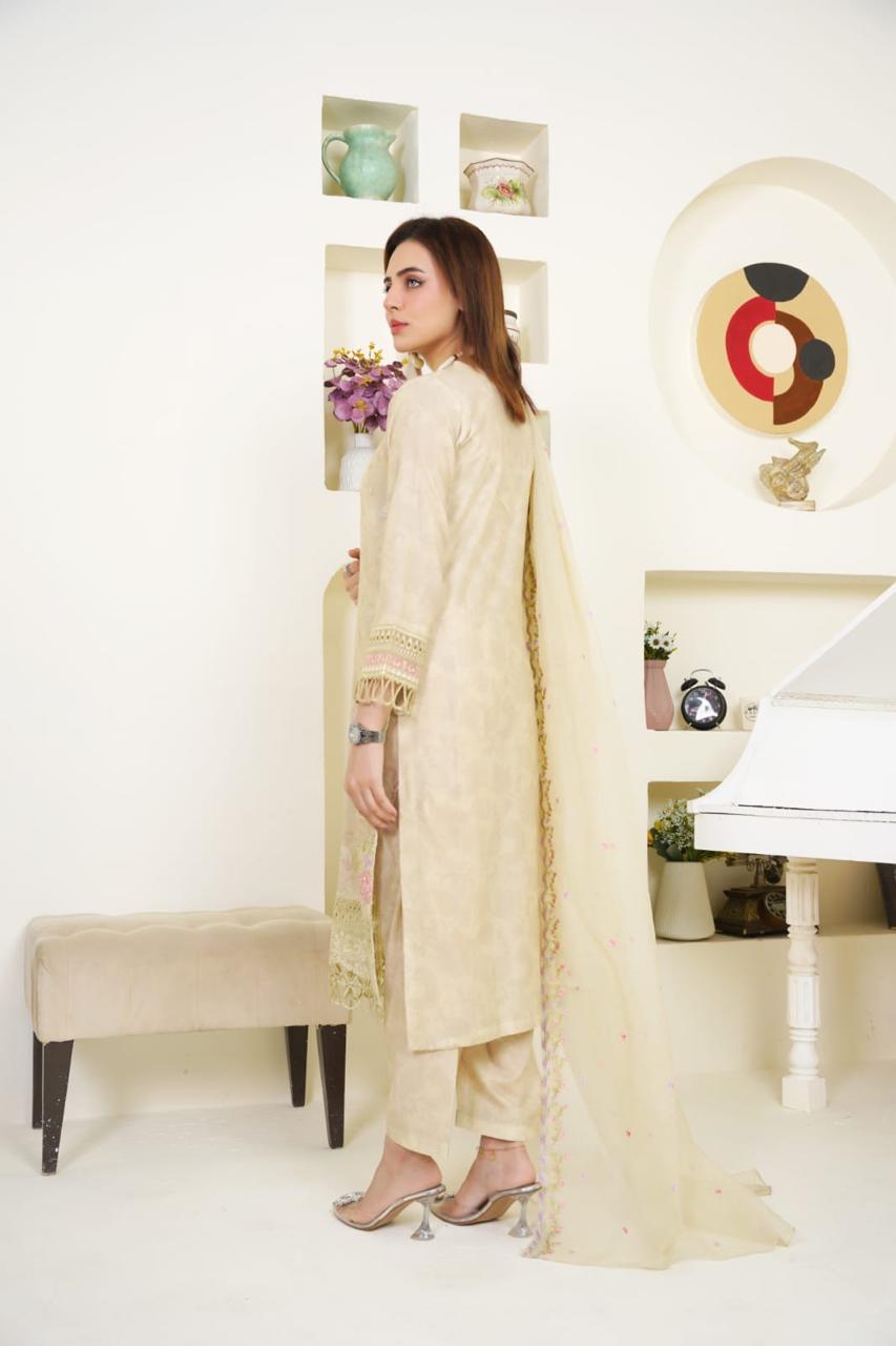 Woman in a cream traditional outfit standing in a room with decor elements.