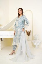 Woman in a floral dress holding a white dupatta in a decorative setting