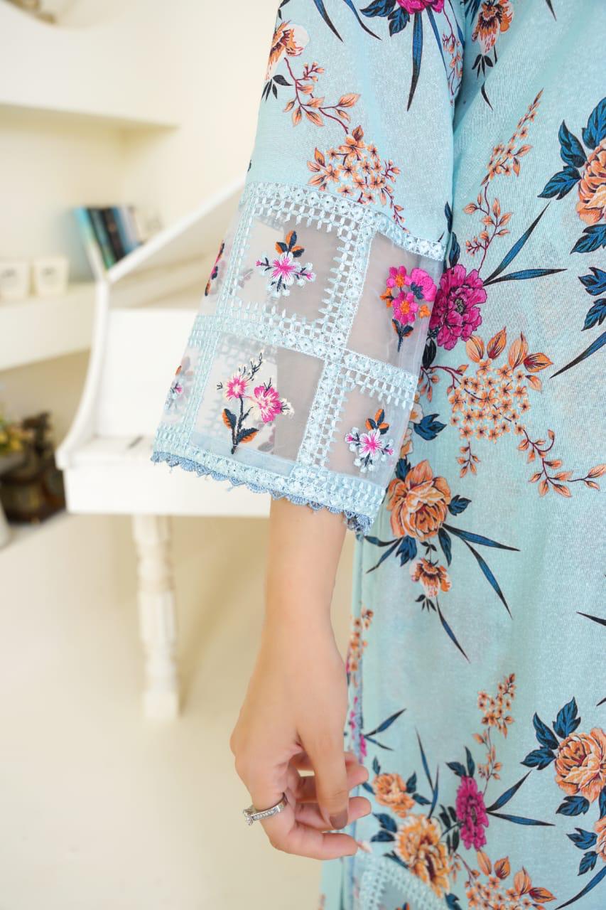 Close-up of a person wearing a light blue floral dress with a blurred indoor background